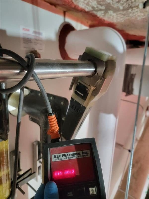 AMI weld head on stainless tube with an Arc Machines remote pendant reading WELD