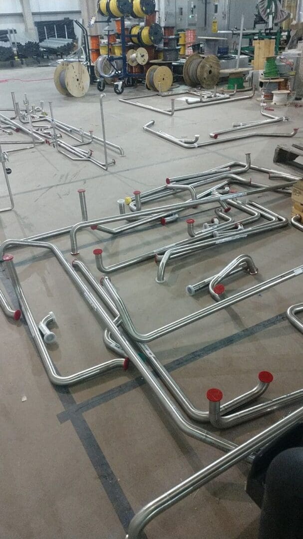 Orbital welded stainless spools staged on a shop floor, ends capped